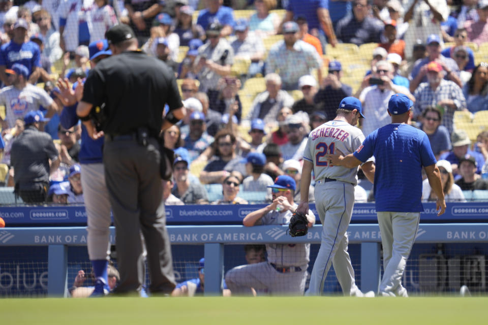 New York Mets starting pitcher Max Scherzer (21) leaves the field after being ejected from the game for a problem with his glove during the fourth inning of a baseball game in Los Angeles, Wednesday, April 19, 2023. Scherzer was ejected from the game. Manager Buck Showalter, left, disputes the call with umpire Dan Bellino. (AP Photo/Ashley Landis)