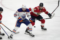 Edmonton Oilers center Connor McDavid (97) and Florida Panthers defenseman Brandon Montour (62) go for the puck during the third period of an NHL hockey game, Saturday, Nov. 12, 2022, in Sunrise, Fla. (AP Photo/Lynne Sladky)