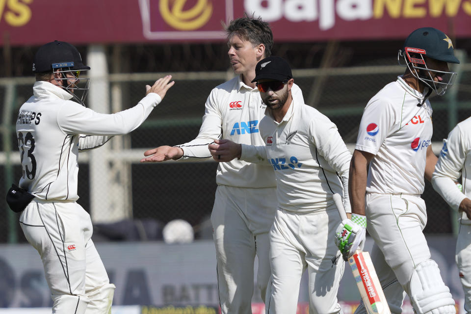 Pakistan's Shan Masood, right, walks off the field as New Zealand's Michael Bracewell, second left, celebrates with teammates after his dismissal during the fifth day of the second test cricket match between Pakistan and New Zealand, in Karachi, Pakistan, Friday, Jan. 6, 2023. (AP Photo/Fareed Khan)