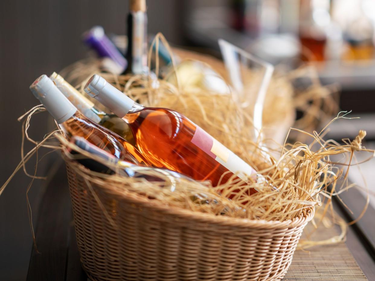 scrumptious wine bottles standing horizontally in a picnic basket.