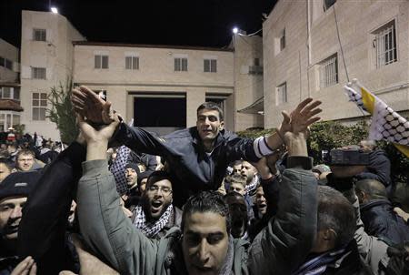 A prisoner (C) released from an Israeli prison is welcomed by relatives in the West Bank city of Ramallah early December 31, 2013. REUTERS/Ammar Awad