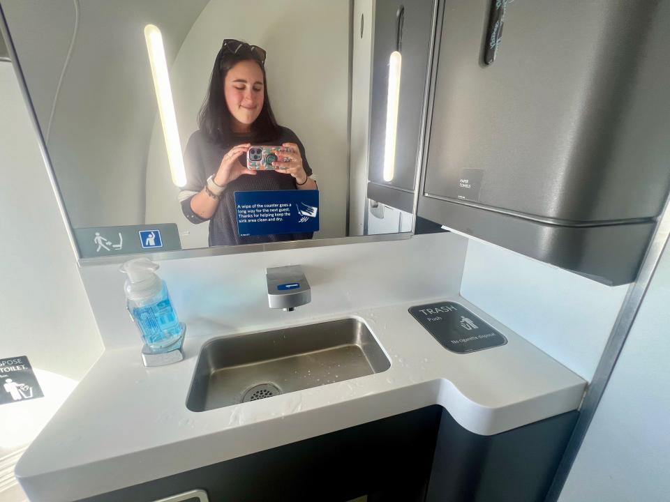 The author standing in the Delta A220 lavatory in the mirror.