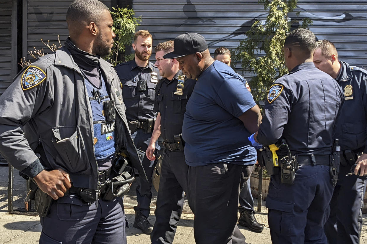 New York City Police Department officers handcuff subway shooting suspect Frank R. James in the East Village section, of New York, Wednesday, April 13, 2022. (AP)