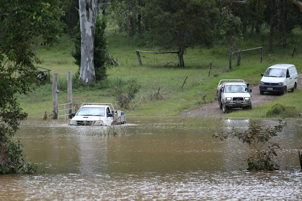 A car attempts to leave their flooded property but turns around near Belli Creek, on the Sunshine Coast, Queensland, Wednesday. Source: AAP