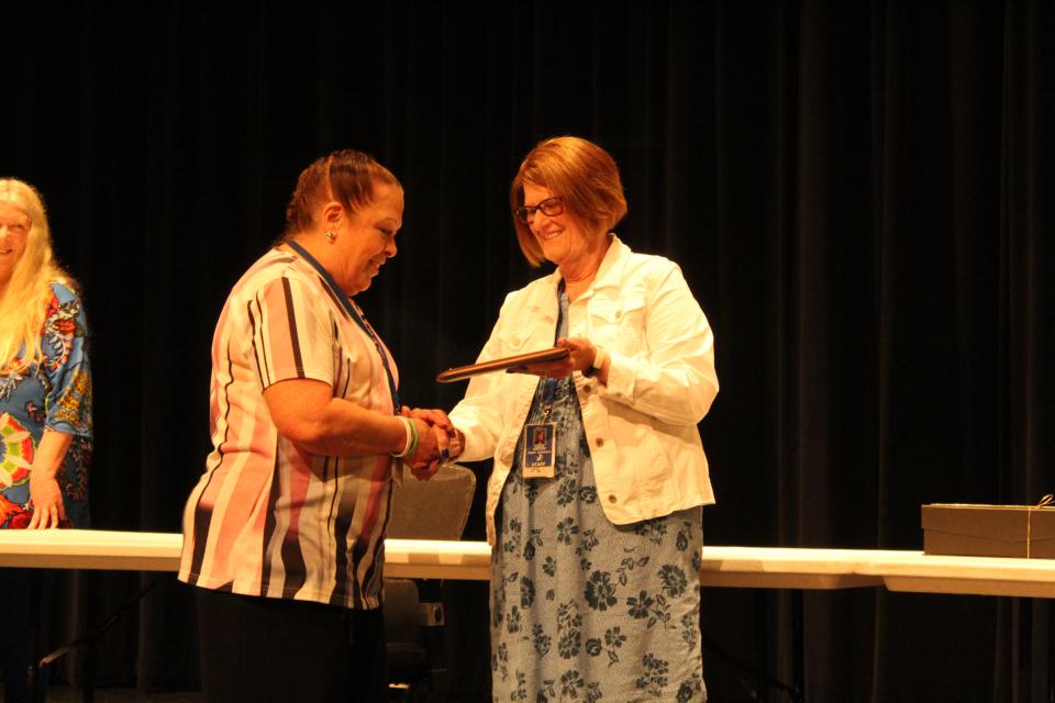 Linda Andorf presents retiree Barbara Chevalier with a plaque thanking her for her 28 years as a middle school para during a presentation on Wednesday, May 31, 2023.