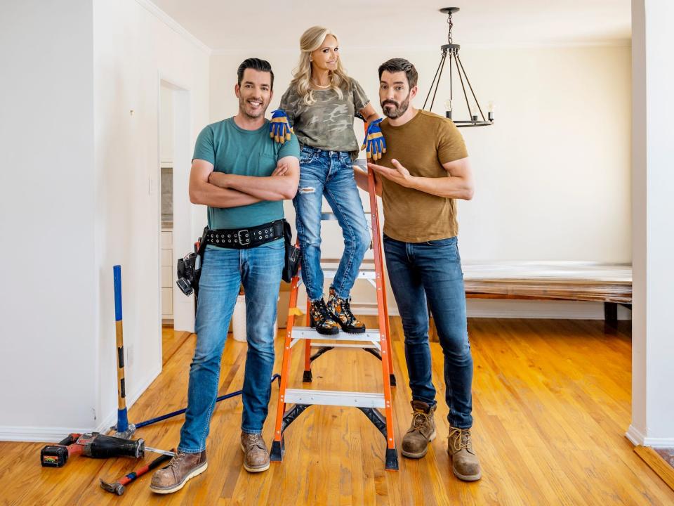 Kristin Chenoweth stands on a ladder between Drew and Jonathan Scott.