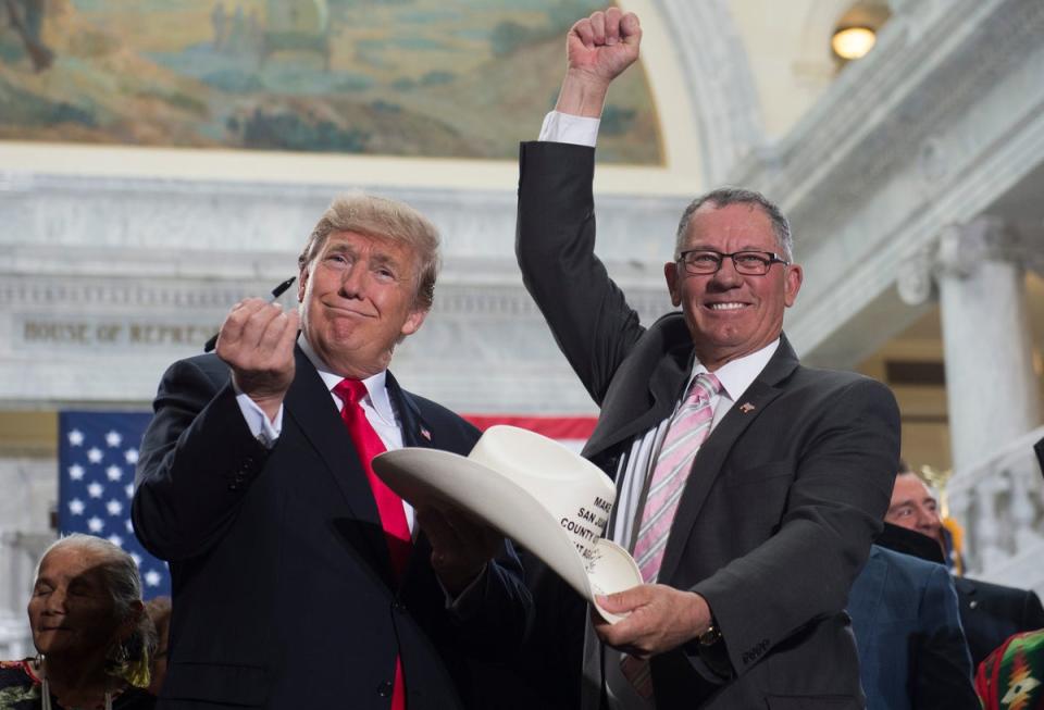 US President Donald Trump holds up a pen after signing the hat of Bruce Adams, Chairman of the San Juan County Commission (AFP via Getty Images)