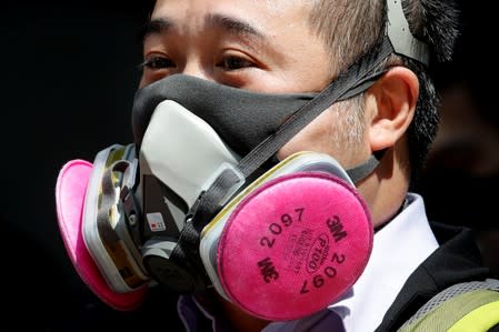 An anti-government protester wearing a mask attends a lunch time protest, after local media reported on an expected ban on face masks under emergency law, at Central, in Hong Kong