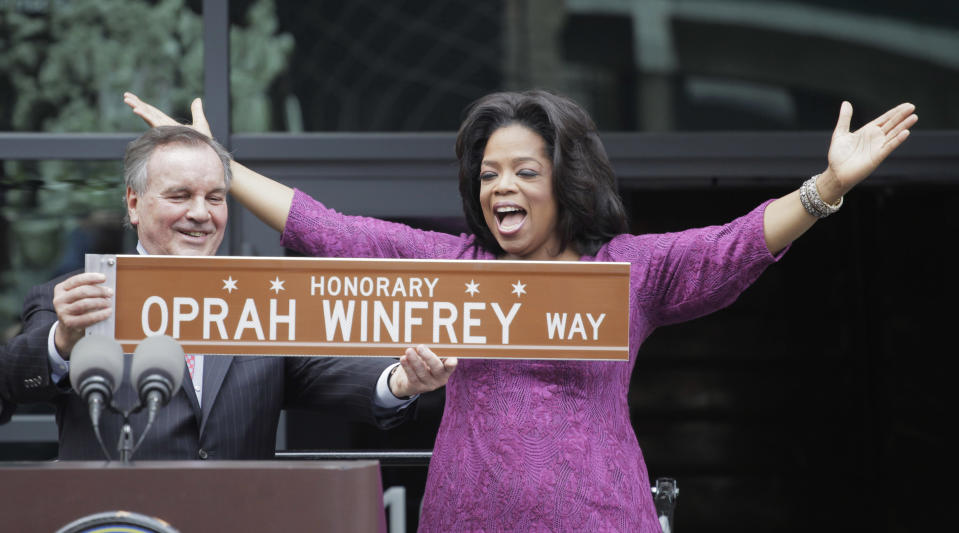 FILE-This May 11, 2011, file photo shows Chicago Mayor Richard M. Daley presenting TV talk-show host Oprah Winfrey with a sign after a street was named in her honor outside her Harpo Studios in Chicago. Winfrey is selling Harpo Studios in Chicago to a developer, but the studio will remain on the property for another two years. Harpo Inc. said in a statement that it has entered into a purchasing agreement with Sterling Bay Cos. for the four-building campus on Chicago's West Side. (AP Photo/M. Spencer Green, File)