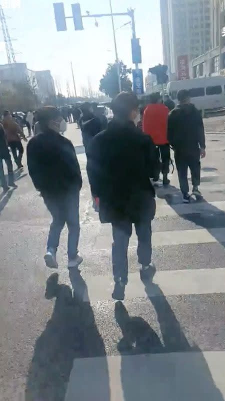 Un grupo de personas parece caminar hacia la fábrica de Foxconn tras una protesta en su planta de Zhengzhouu, China