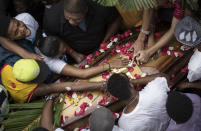 Relatives and friends of Douglas Rafael da Silva Pereira mourn around his coffin during his burial in Rio de Janeiro, Brazil, Thursday, April 24, 2014. A protest followed the burial of Pereira, whose shooting death sparked clashes Tuesday night between police and residents of the Pavao-Pavaozinho slum. (AP Photo/Felipe Dana)