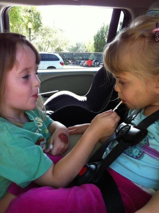 Carly helps little sister Brooklyn enjoy a lollipop. Brooklyn has a gross motor disability (Rett Syndrome) so she can't use her hands purposefully.