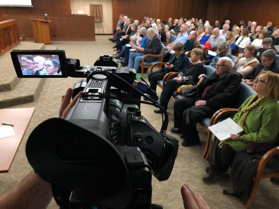 A WNDU-TV camera focuses on library board member Alan Feldbaum and library Director Stephanie Murphy on Dec. 12, 2023, among a full crowd at the St. Joseph County Commissioners meeting.