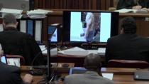 An image taken from the court pool TV via AP showing on screen a police photograph of Oscar Pistorius from the waist up and from the left side, showing blood on his shorts and parts of his body, with a tattoo visible on his back which was shown to the court in Pretoria, at his murder trial Friday, March 14, 2014. Prosecutors displayed two photos on TV monitors in the courtroom. A second photo shows him standing on his blood-stained prosthetic legs and wearing shorts covered in blood, taken shortly after the athlete fatally shot his girlfriend. The photographs were taken in the garage of Pistorius’ Pretoria home where the athlete killed Reeva Steenkamp in the early hours of Valentine’s Day, 2013, a former policeman testified. (AP Photo/Court Pool via AP)