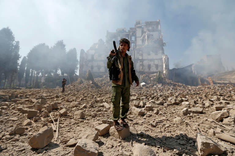 Yemeni Huthi rebel fighters inspect the damage after a reported Saudi-led coalition air strike hit presidential palace in the capital Sanaa on December 5, 2017