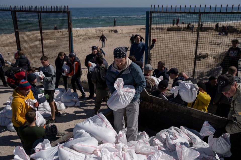 Volunteers load a vehicle with sandbags to defend the city, in Odesa, southern Ukraine, on Wednesday, March 23, 2022. Western officials say that Ukrainian resistance has halted much of Russia's advance. (AP Photo/Petros Giannakouris) ORG XMIT: NYAG503