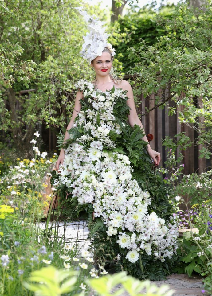 Ce mannequin pose avec ce chef d’œuvre, fait de feuillage et de vraies fleurs. 