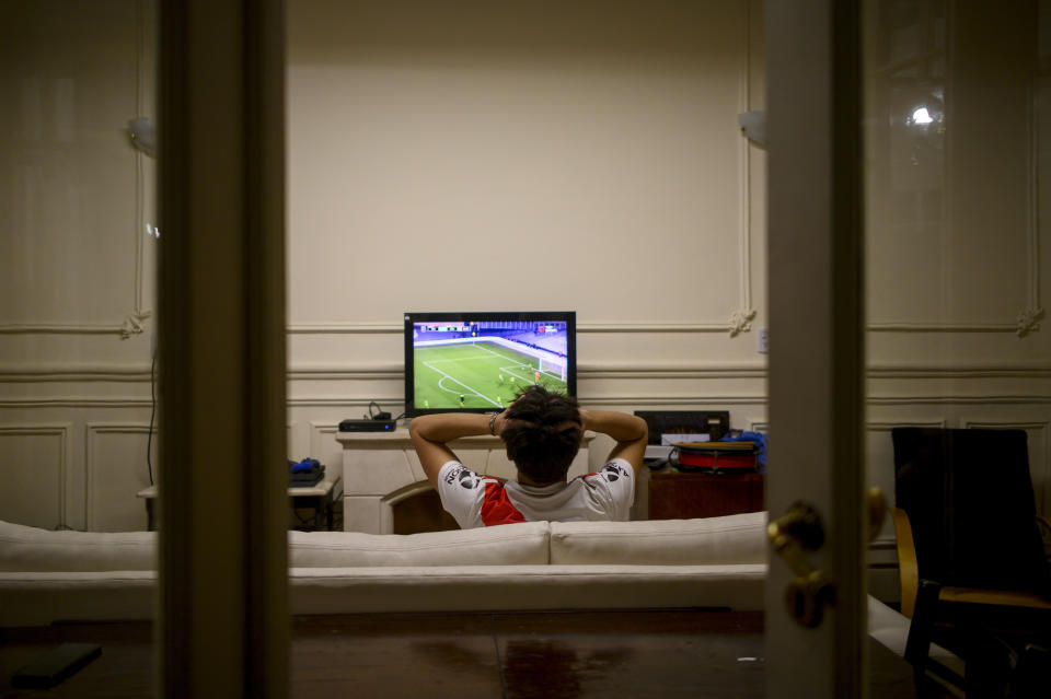 Juan Camisassa, hincha de River Plate, mira a su equipo jugar contra Aldosivi por televisión en su casa, el jueves 26 de agosto de 2021. (AP Foto/Mario de Fina)