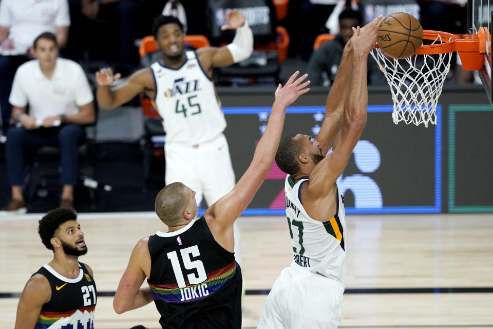 Utah Jazz's Rudy Gobert, right, misses a dunk against Denver Nuggets' Nikola Jokic (15) during the second half of an NBA basketball first round playoff game, Monday, Aug. 17, 2020, in Lake Buena Vista, Fla. Nuggets' Jamal Murray (27) and Jazz's Donovan Mitchell (45) look on during the play. (AP Photo/Ashley Landis, Pool)