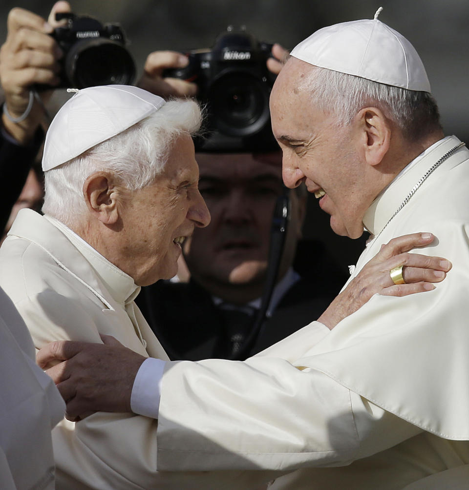 FILE - In this Sept. 28, 2014 file photo, Pope Francis, right, hugs Pope Benedict XVI prior to the start of a meeting with elderly faithful in St. Peter's Square at the Vatican. Retired Pope Benedict XVI has broken his silence to reaffirm the value of priestly celibacy, co-authoring a bombshell book at the precise moment that Pope Francis is weighing whether to allow married men to be ordained to address the Catholic priest shortage. (AP Photo/Gregorio Borgia, File)