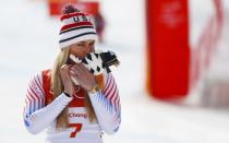 Alpine Skiing - Pyeongchang 2018 Winter Olympics - Women's Downhill - Jeongseon Alpine Centre - Pyeongchang, South Korea - February 21, 2018 - Bronze medallist Lindsey Vonn of the U.S. kisses a Soohorang mascot plush doll during the flower ceremony. REUTERS/Leonhard Foeger