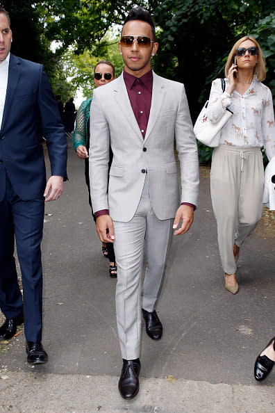 Formula 1 race car driver Lewis Hamilton, who’s rumored to be dating Kendall Jenner, made his way to the Burberry show in a light gray suit, burgundy button down, matching shoes, and tinted shades.