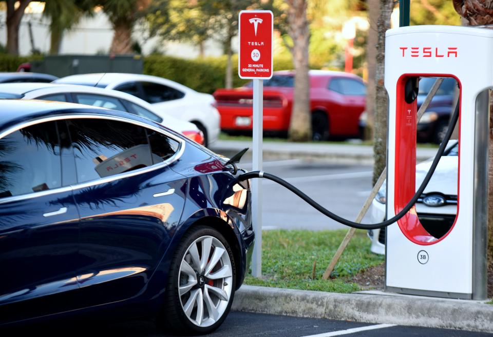 A Tesla Model 3 charges at a Supercharger.