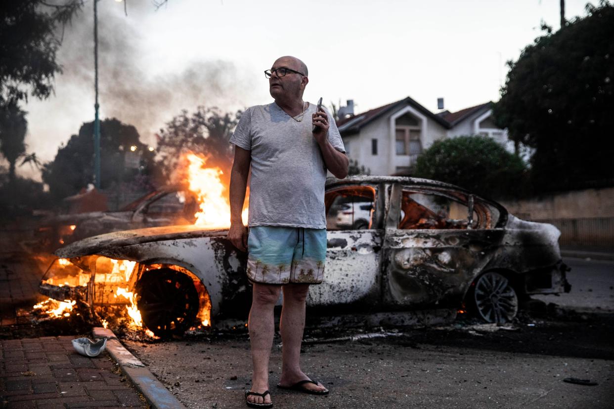 Jacob Simona stands by his burning car during clashes with Israeli Arabs and police in the Israeli mixed city of Lod, Israel on Tuesday, May 11, 2021.