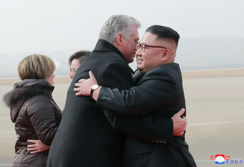 In this Sunday, Nov. 4, 2018 photo by the North Korean government, Cuban President Miguel Diaz-Canel, second from right, hugs North Korean leader Kim Jong Un upon arrival at Pyongyang International Airport in Pyongyang, North Korea. Both, hoping to get out from under U.S. economic sanctions, agreed to expand and strengthen their strategic relations, North Korea's state media reported Monday, Nov. 5, 2018. Seen in the background are their wives, Lis Cuesta Perara, left, and Ri Sol Ju. Independent journalists were not given access to cover the event depicted in this image distributed by the North Korean government. The content of this image is as provided and cannot be independently verified. Korean language watermark on image as provided by source reads: "KCNA" which is the abbreviation for Korean Central News Agency. (Korean Central News Agency/Korea News Service via AP)