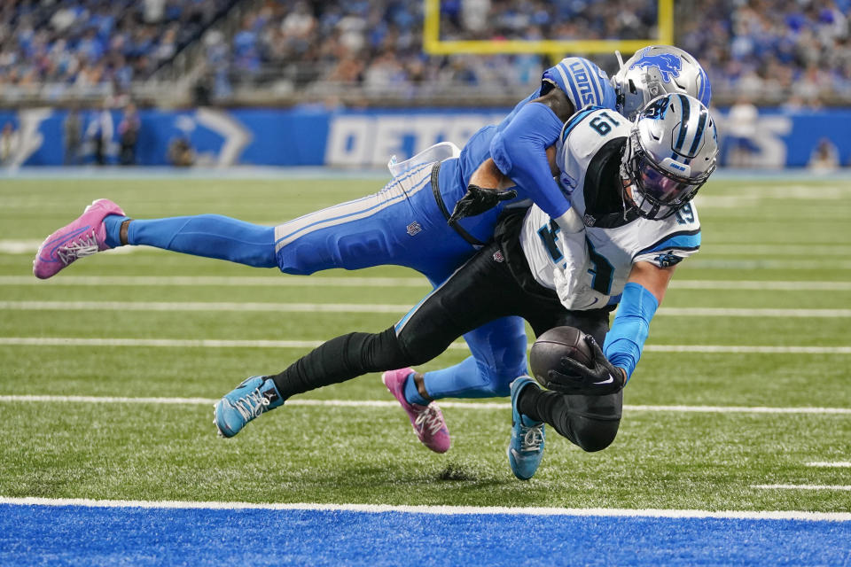 Carolina Panthers wide receiver Adam Thielen (19) scores a touchdown as Detroit Lions safety Tracy Walker III (21) tries to tackle in the second half of an NFL football game in Detroit, Sunday, Oct. 8, 2023. The Lions won 42-24. (AP Photo/Paul Sancya)