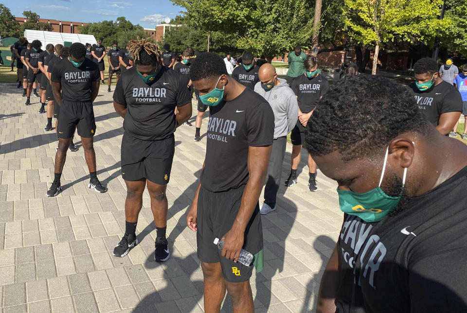 Members of the Baylor football team including Dave Aranda, bow their heads during a prayer after marching around campus, Thursday, Aug. 27, 2020, in Waco, Texas, protesting the shooting of Jacob Blake in Wisconsin. (Rod Aydelotte/Waco Tribune-Herald via AP)