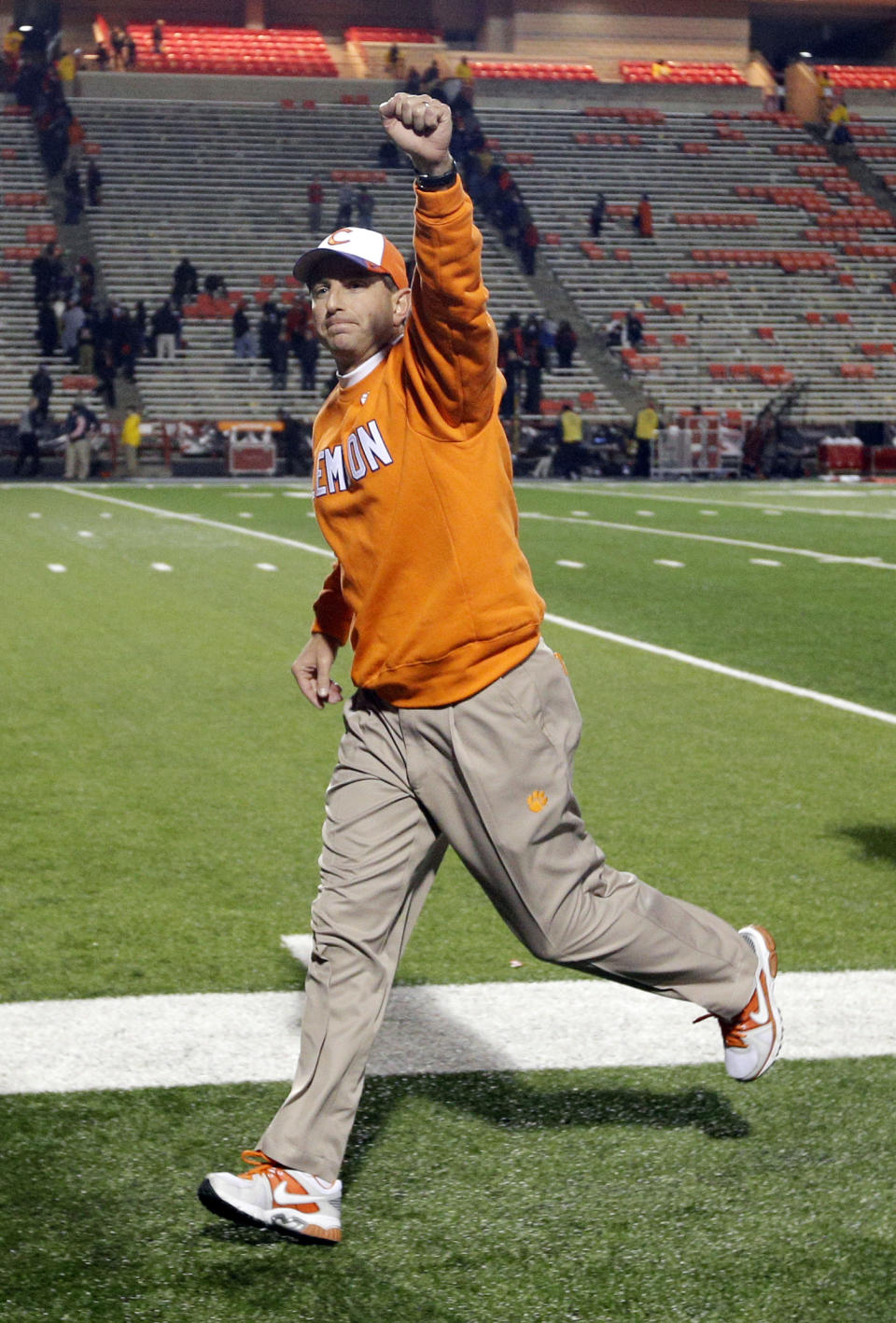 FILE - In this Oct. 26, 2013, file photo, Clemson head coach Dabo Swinney acknowledges fans as he runs off the field after an NCAA college football game against Maryland in College Park, Md. Swinney received a new, eight-year contract and a raise that increased his total pay for next season to $3.15 million. (AP Photo/Patrick Semansky, File)