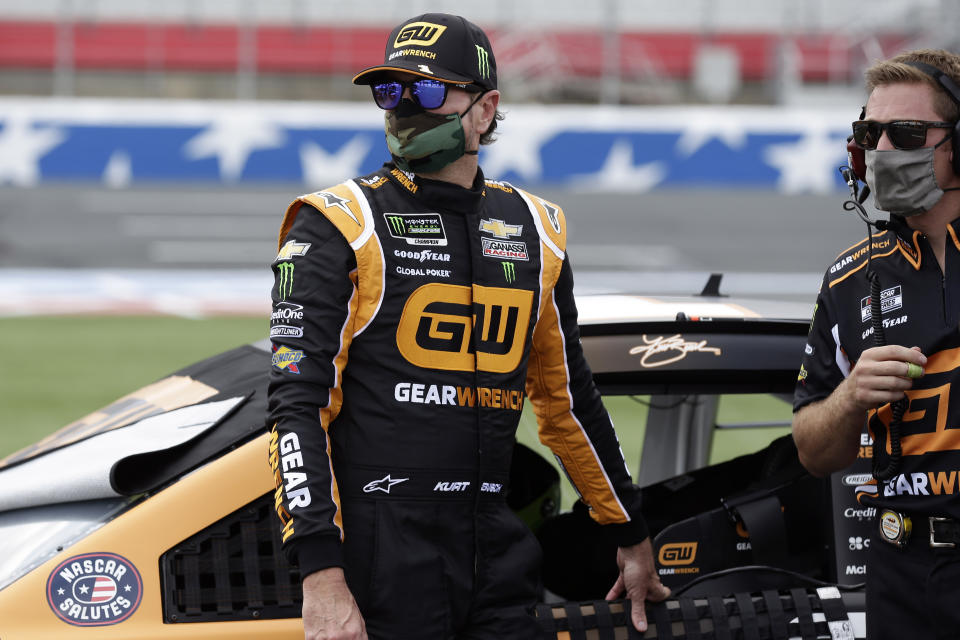 Driver Kurt Busch, left, watches on pit road during qualifying prior to a NASCAR Cup Series auto race at Charlotte Motor Speedway Sunday, May 24, 2020, in Concord, N.C. Busch won the pole position for the race. (AP Photo/Gerry Broome)