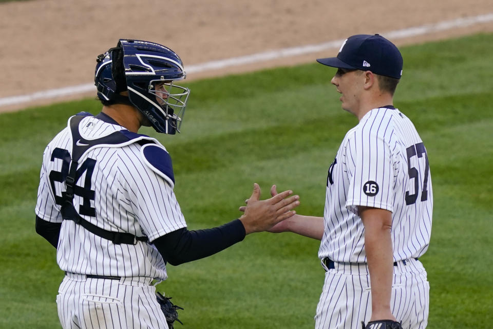 New York Yankees relief pitcher Chad Green (57) and catcher Gary Sanchez (24) celebrate after closing the ninth inning of a baseball game against the Toronto Blue Jays, Saturday, April 3, 2021, in New York. (AP Photo/John Minchillo)