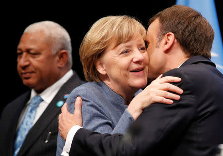 French President Emmanuel Macron kisses German Chancellor Angela Merkel during the COP23 U.N. Climate Change Conference in Bonn, Germany, November 15, 2017. REUTERS/Wolfgang Rattay