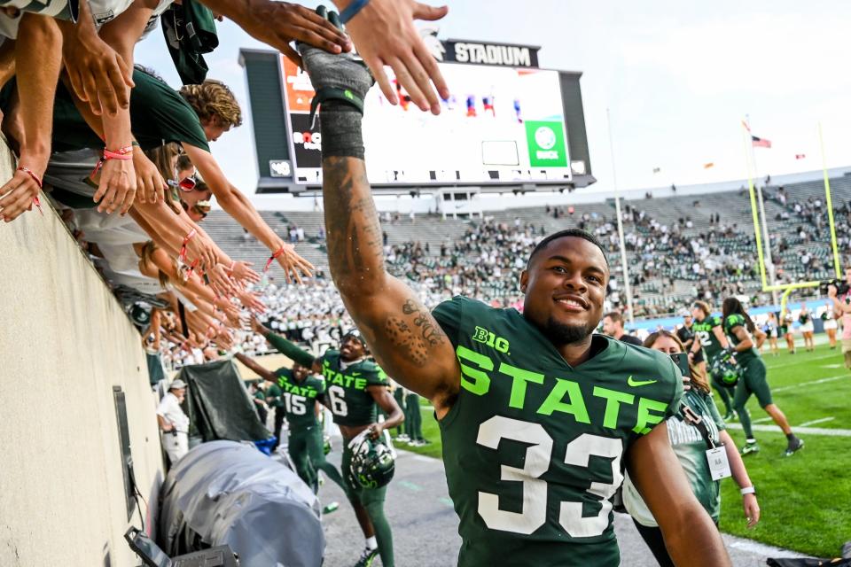 Michigan State's Kendell Brooks slaps hands with fans after beating Akron on Saturday, Sept. 10, 2022, at Spartan Stadium in East Lansing.