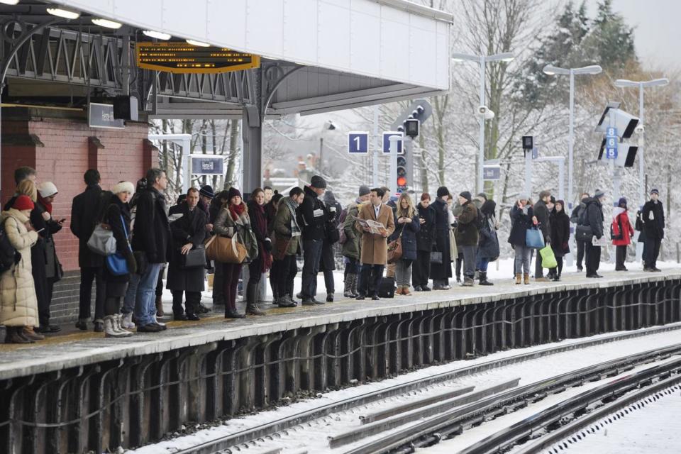 Commuters in the snow at Herne Hill station in south London (Facundo Arrizabalaga/EPA)