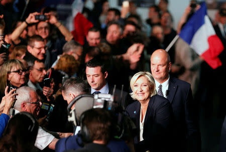 Marine Le Pen, French National Front (FN) political party leader and candidate for French 2017 presidential election, waves to supporters as she arrives surrounded by security members at a political rally in Bordeaux, France, April 2, 2017. REUTERS/Regis Duvignau