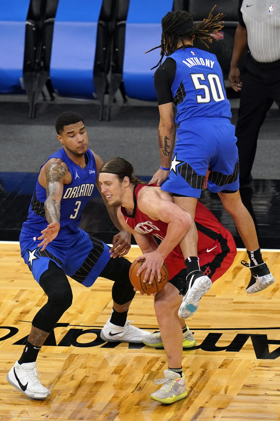 Orlando Magic guard Cole Anthony (50) fouls Houston Rockets forward Kelly Olynyk, center, in front of Orlando Magic forward Chuma Okeke (3) during the closing moments of the second half of an NBA basketball game, Sunday, April 18, 2021, in Orlando, Fla. (AP Photo/John Raoux)