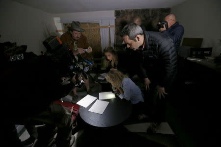 News media look at documents left inside the home of suspects Syed Rizwan Farook and Tashfeen Malik in Redlands, California December 4, 2015, following Wednesday's attacks. REUTERS/Mario Anzuoni