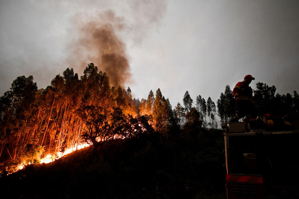 <p>A firefighter stands on top of a fire truck during a wildfire in Penela, Coimbra, central Portugal, June 18, 2017. (Patricia De Melo Moreira/AFP/Getty Images) </p>