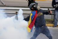 <p>A demonstrator throws back a tear gas canister during rally against Venezuela’s President Nicolas Maduro in Caracas, Venezuela May 1, 2017. (Photo: Carlos Garcia Rawlins/Reuters) </p>