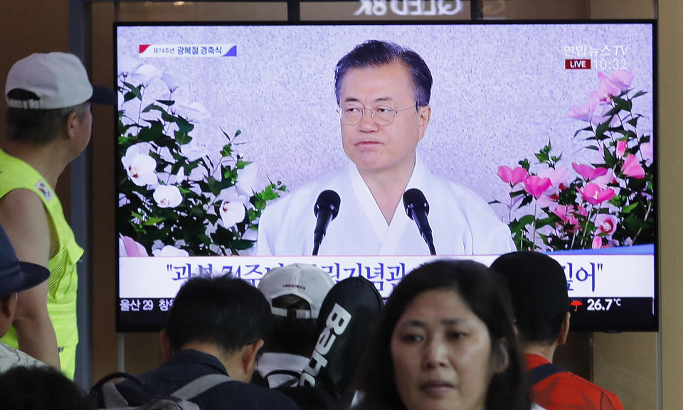 People watch a TV screen showing a live broadcast of South Korean President Moon Jae-in's speech during a ceremony to celebrate the Korean Liberation Day, marking the 74th anniversary of Korea's liberation from the Japanese colonial rule, at the Seoul Railway Station in Seoul, South Korea, Thursday, Aug. 15, 2019. The signs read: "Korean Liberation Day."(AP Photo/Ahn Young-joon)