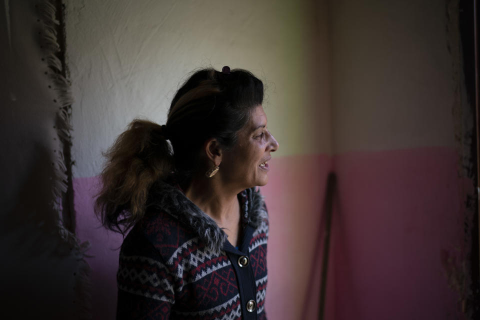 In this Nov. 14, 2018, photo, Monika Krcova talks to a neighbor while standing in her house at the Podhorany village near Kezmarok, Slovakia. Krcova did not want to follow the official guidelines and remain in the hospital for four days after her third baby’s birth. And so she escaped. Slovakia’s Ministry of Health recommends four-day stays for mothers and babies, regardless of their health. Many hospitals seeking insurance reimbursements have turned that into a mandate. (AP Photo/Felipe Dana)