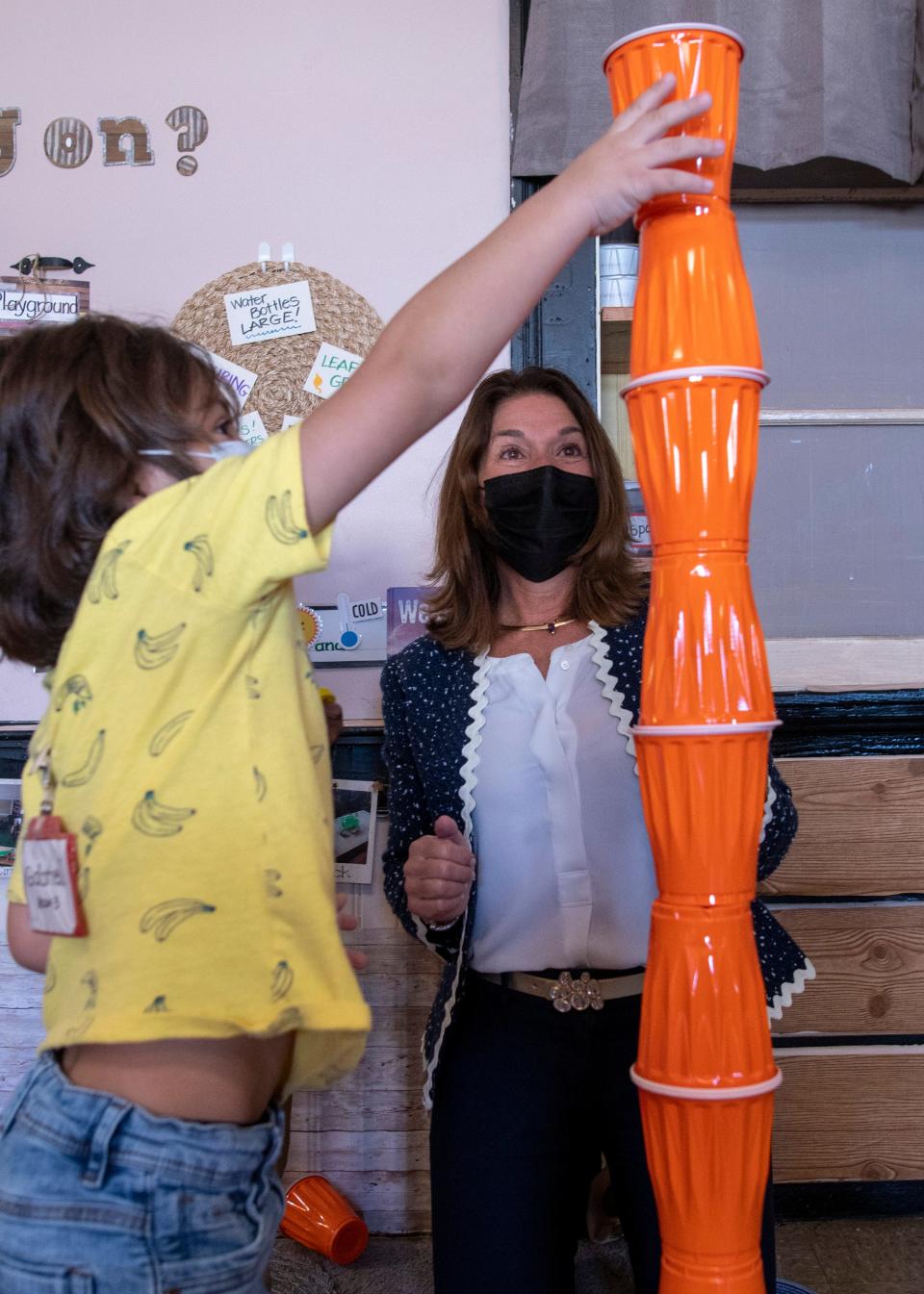 Lt. Gov. Karyn Polito encourages a child to stack cups at the Greendale Head Start in Worcester in October 2021.