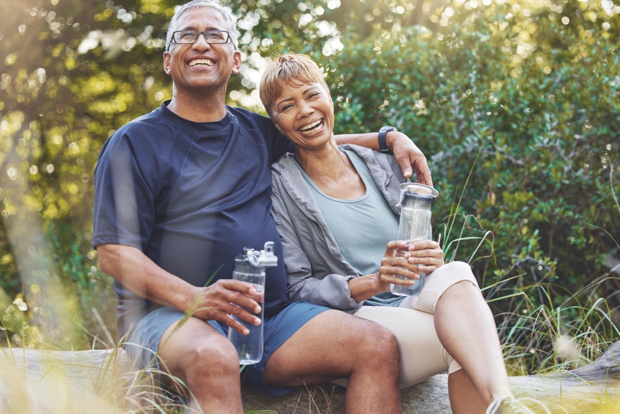 Nature, hiking and portrait of a senior couple resting while doing outdoor walk for exercise. Happy, smile and elderly man and woman in retirement trekking together for wellness in a forest in Brazil