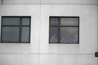 <p>Those still inside the building peek out the windows after a shooting killing one and wounding six others at Bronx Lebanon Hospital Center Friday, June 30, 2017, in New York. (AP Photo/Michael Noble) </p>