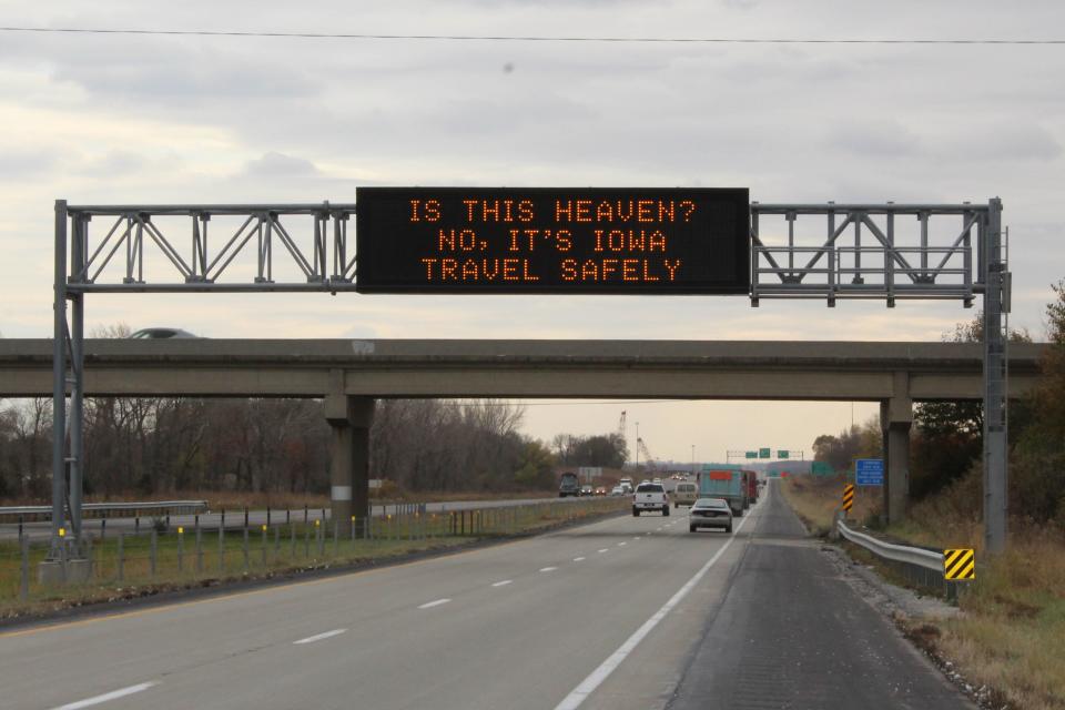 An Iowa Department of Transportation roadside safety sign saying: "Is this heaven? No, it's Iowa. Travel safely."