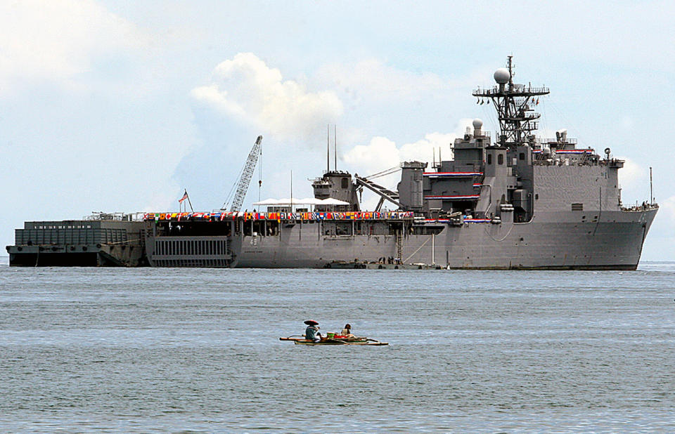 FILE - In this May 31, 2007, file photo, a Filipino fisherman sails past the USS Harpers Ferry, the U.S. Navy's amphibious warship, as it anchors off the waters of Zamboanga city in southern Philippines. Forces from the U.S. and Brunei, whose South China Sea claims overlap with those of China, are holding joint exercises simulating the securing of a beach head and conducting jungle warfare and combat medical training inland. The U.S. amphibious dock landing ship USS Harpers Ferry members of the 11th Marine Expeditionary Unit arrived in Brunei more than a week ago in preparation for the drills known as Cooperation Afloat Readiness and Training, or CARAT, the Navy said on Tuesday, Oct. 15.(AP Photo/Al Jacinto, File)