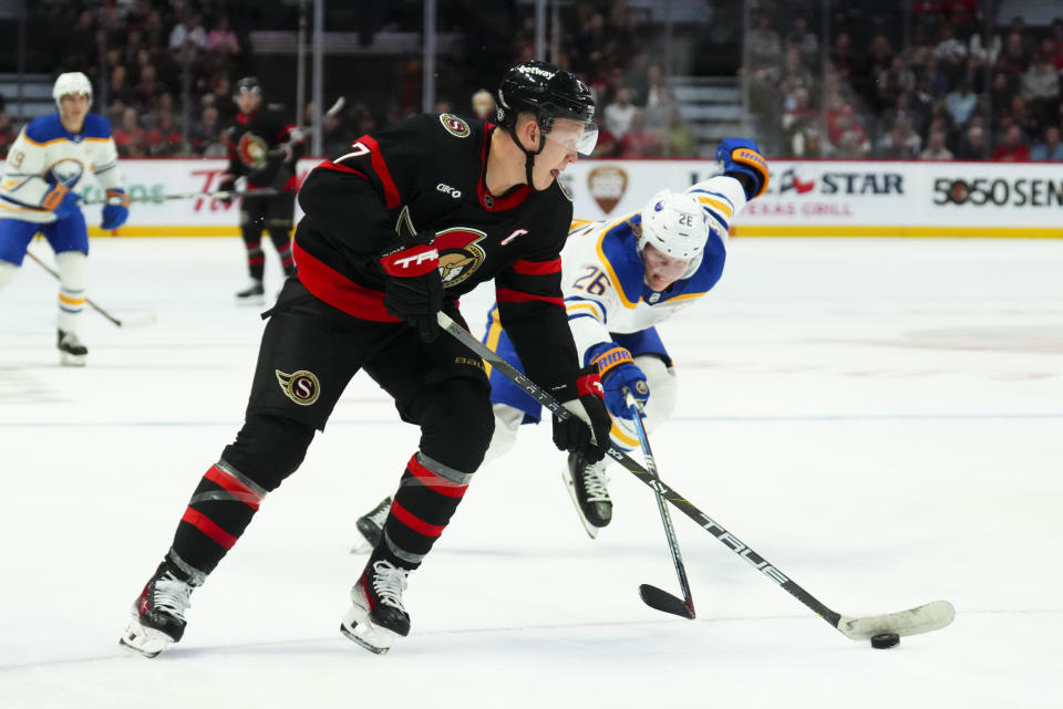 Ottawa Senators left wing Brady Tkachuk (7) skates the puck to the net as Buffalo Sabres' Rasmus Dahlin (26) defends during the second period of an NHL hockey game Tuesday, Oct. 24. 2023, in Ottawa, Ontario. (Sean Kilpatrick/The Canadian Press via AP)